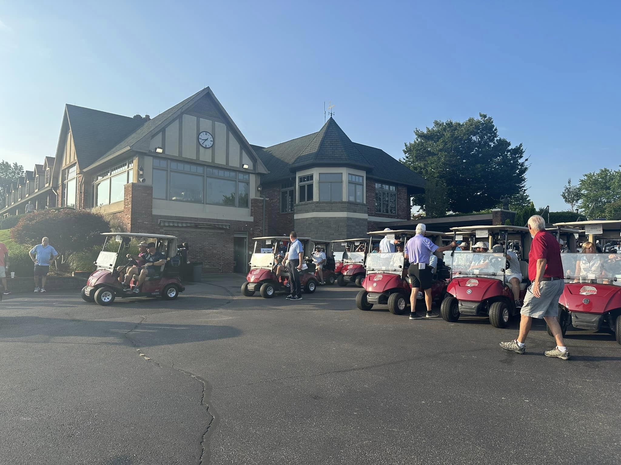 Image of the Covered Bridge Golf Course Clubhouse with golf carts scattered around.