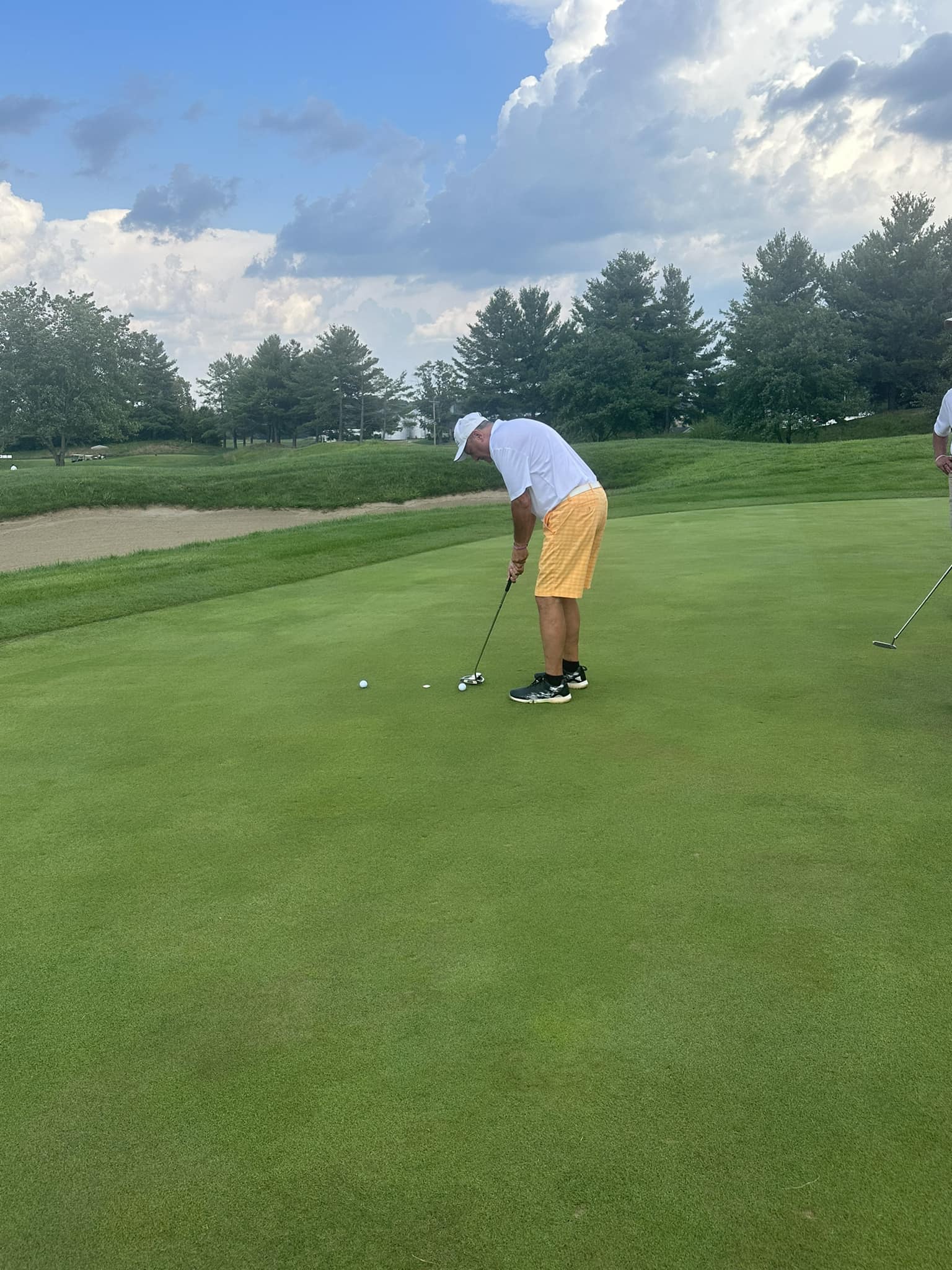 A golfer lining up for a put.
